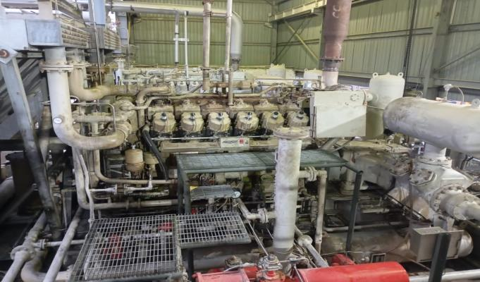 Original field photograph of the gas engine and compressor package at EMP Bentu, Kerinci